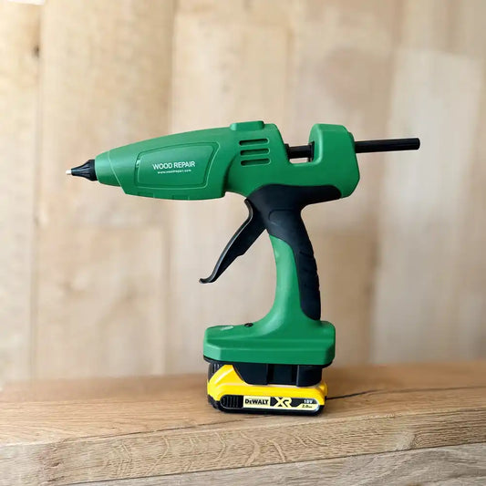 WoodRepair Akku-Heißklebepistole mit DeWalt 18V Akku auf Holzoberfläche, grün-schwarzes Design