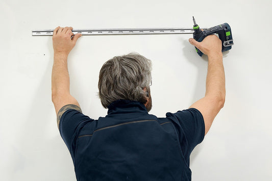 Festool CXS 12 Akku-Bohrschrauber bei Anwendung an Wand mit Schleifleiste und Bohrfutter