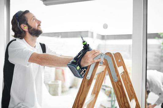 Festool CXS 18 C 3,0-Plus Akku-Bohrschrauber mit C-Form-Griff bei Anwendung an Holzleiter