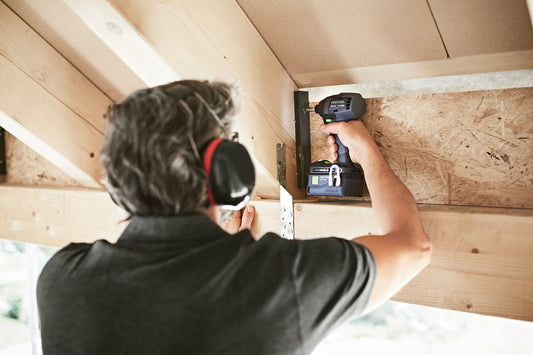 Festool TID 18-Basic Akku-Schlagschrauber in Anwendung beim Verschrauben an Holzkonstruktion, Handwerker mit Gehörschutz