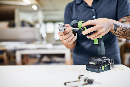 Festool QUADRIVE TPC 18/4 Akku-Schlagbohrschrauber mit Wechselakku und grünem FastFix-Aufsatz in Werkstatt