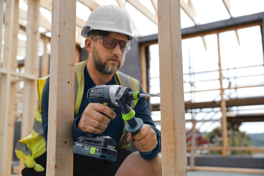 Festool Akku-Bohrschrauber TBX 4 mit 18V Akku in Anwendung auf Baustelle, Handwerker mit Schutzausrüstung