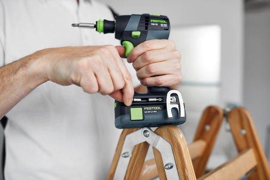 Festool TXS 18-Basic Akku-Bohrschrauber in Hand mit 3,0 Ah Li-ion Akku auf Leiter, Anwendungsbeispiel