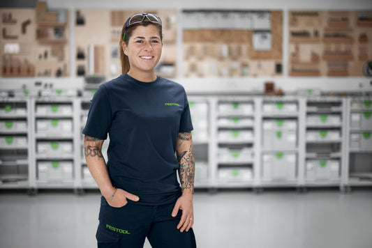 Festool UVEX SG-FT1 Schutzbrille mit UV-400-Schutz in Dunkelblau, getragen von Mitarbeiterin in Lagerhalle