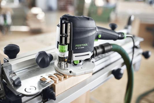 Festool OF 1010 REBQ-Plus Oberfräse auf Führungsschiene mit Fräser und Holzwerkstück in Werkstatt.