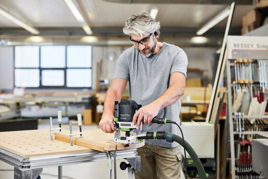 Festool OF 1400 Oberfräse mit Absaughaube und LED-Lichtmodul bei Fräsarbeit an Holzwerkstück