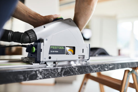 Festool TS 55 FEBO Tauchsäge im Einsatz beim Schneiden einer dunklen Platte mit Führungsschiene
