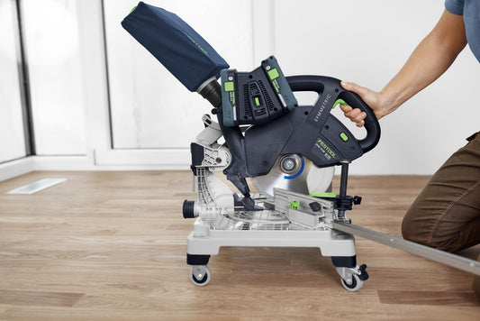Festool Kapp- und Gehrungssäge mit Sägeblatt auf Holzarbeitstisch, Hand hält Maschinenkopf