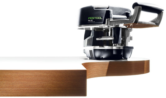 Festool Kantenanleimer KA 65 mit Führungstisch bei der Verarbeitung einer Holzkante, schwarzes Gehäuse mit grünem Logo