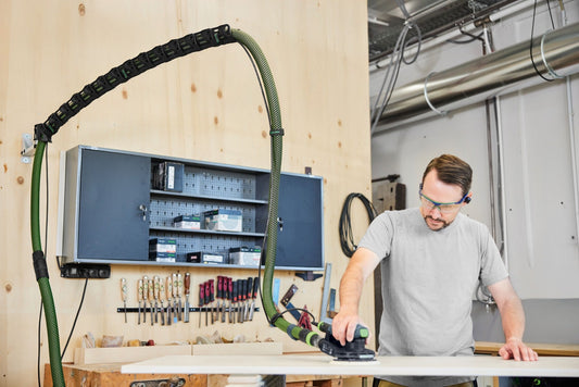 Festool Absaugarm CT-ASA FLX W in Werkstatt, Handwerker nutzt Absaugarm beim Schleifen, grüner Flexarm mit Kettenglieder