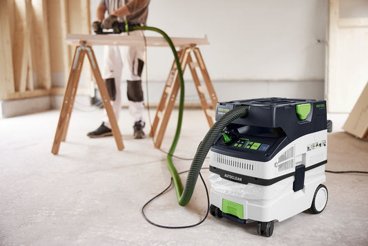 Festool CTH MIDI I AC Absaugmobil mit grünem Schlauch bei Holzarbeiten auf der Baustelle im Einsatz