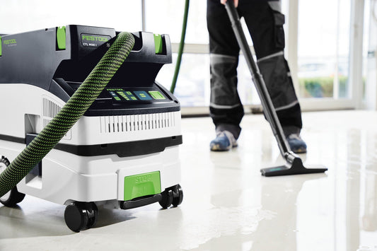 Festool CTL MINI Absauganlage mit grünem Saugrohr in Anwendung auf Baustelle