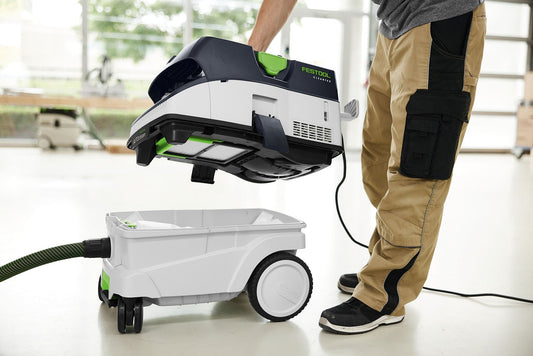 Festool CLEANTEC CTM 26 EI AC Absaugmobil mit Filterabreinigung beim Einsatz auf Baustelle mit Saugschlauch und Behälter.