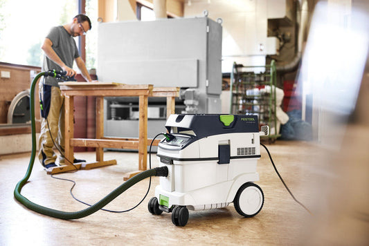 Festool CLEANTEC CTL 36 EI AC Absaugmobil mit grünem Saugschlauch in der Werkstatt bei der Anwendung