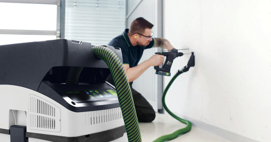 Festool CTLC MIDI Akku-Absaugmobil mit Elektroschrauber in Anwendung, grüner Absaugschlauch, Staubabsaugung