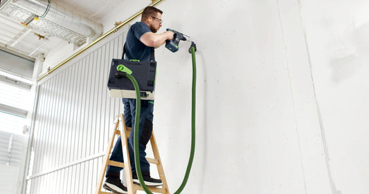 Festool CLEANTEC CTMC SYS Akku-Absaugmobil mit grünem Schlauch bei Wandarbeiten auf Leiter montiert