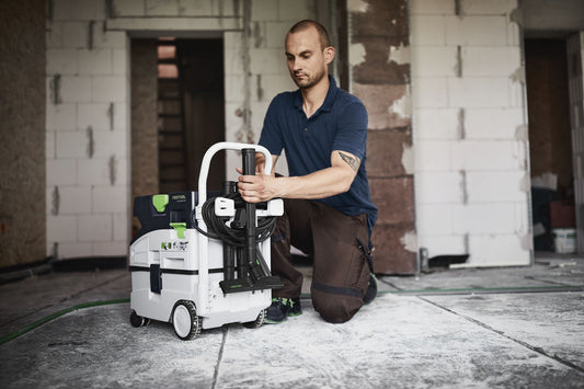 Festool Absaugmobil CLEANTEC CTL MIDI I, Handwerker bedient kompakten Staubsauger auf Baustelle