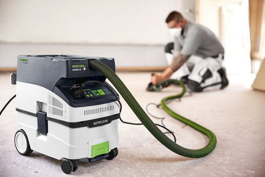 Festool CLEANTEC CTM MIDI I AC Absaugmobil mit Schlauch im Einsatz auf der Baustelle, Arbeiter im Hintergrund