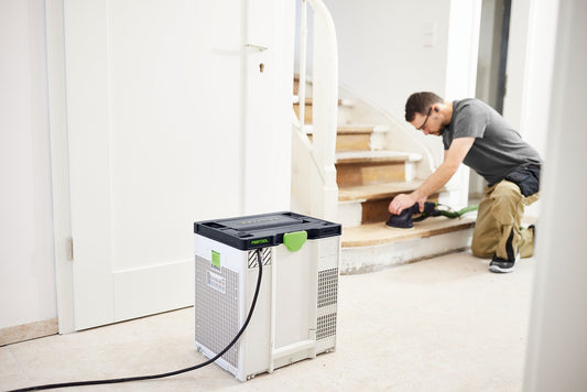 Festool Luftreiniger SYS-AIR M im Einsatz auf Baustelle, Handwerker arbeitet im Hintergrund