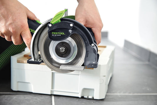 Festool DSC-AG 125 FH Freihand Trennsystem in den Händen, grüne Absaughaube, Systainer im Hintergrund