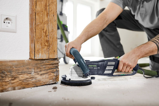 Festool RENOFIX RG 130 ECI Sanierungsschleifer beim Schleifen an Holzleiste und Betonboden.