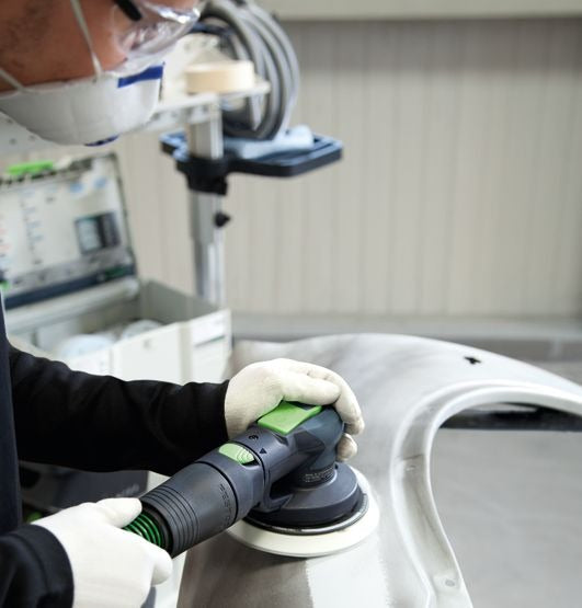 Festool LEX 3 150/3 Druckluft-Exzenterschleifer im Einsatz auf weißem Werkstück mit Schleifteller