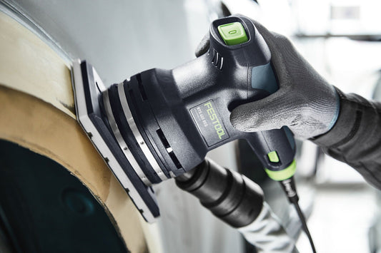 Festool Schleifschuh mit grünem StickFix Klettbelag wird an Holzwerkstück angesetzt, Lüfteröffnungen sichtbar