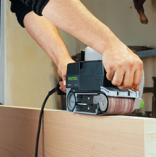 Festool BS 75 E Bandschleifer in Anwendung beim Schleifen eines Holzwerkstücks mit beiden Händen