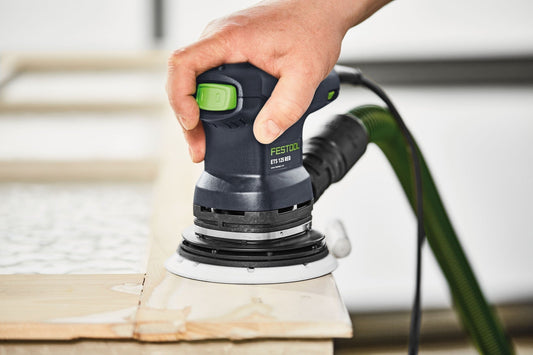 Festool ETS 125 REQ Exzenterschleifer in Anwendung auf Holzwerkstück, grünes Netzkabel sichtbar