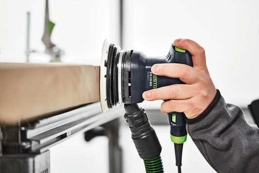 Festool Plug-it-Kabel mit Bajonettverriegelung in der Hand, grüne PUR-Gummiausführung im praktischen Einsatz