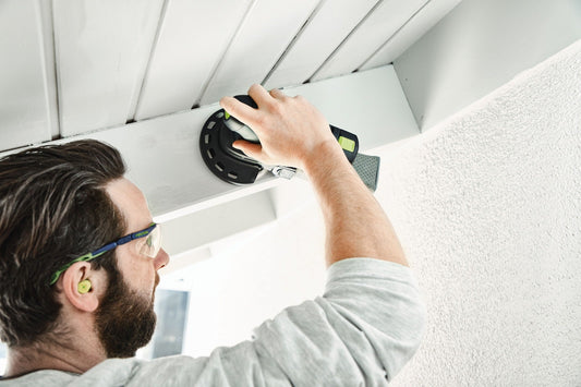 Festool Protection Pad D125 wird von Handwerker an Decke mit Schutzbrille befestigt