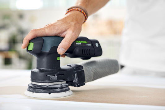 Festool Exzenterschleifer mit Schleifteller in Anwendung auf Holzoberfläche, Nahaufnahme der Bedienung