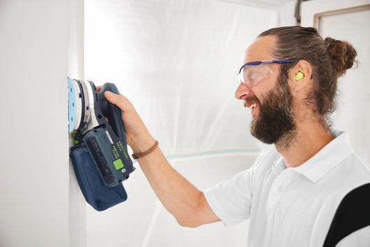 Festool Exzenterschleifer ETSC mit Staubfangbeutel in Anwendung an Wand