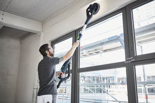 Festool PLANEX LHS 2 Langhalsschleifer bei der Anwendung an Decke, Arbeiter schleift Gipskartondecke mit LED-Lichtring.