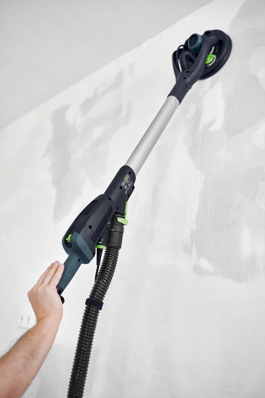 Festool Langhalsschleifer PLANEX LHS 2-M 225 EQ mit Teleskopschaft wird an Wand hochgehalten, Absauganlage angeschlossen.