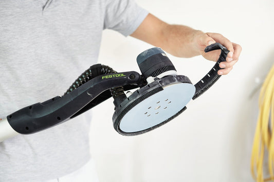 Festool Bürsteneinsatz BE-LHS 225 mit schwarzem Bürstenkranz und weißem Schleifteller in Händen gehalten