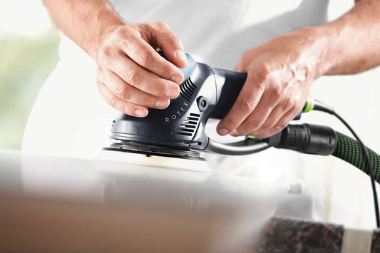Festool ROTEX RO 150 FEQ Exzenterschleifer in Anwendung beim Schleifen einer weißen Oberfläche